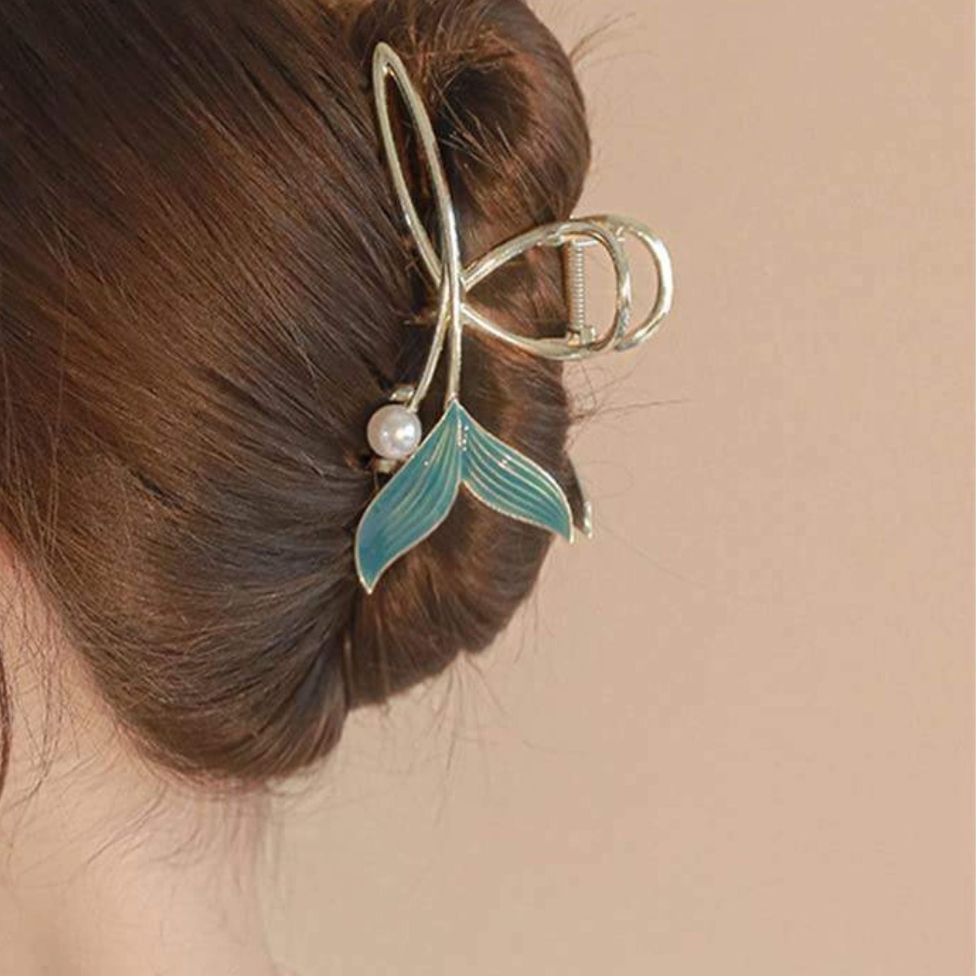 Hair clip with a green leaf and pearl detail in a person's hair for women & GIRLS 